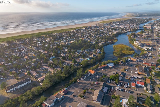 birds eye view of property featuring a water view and a beach view