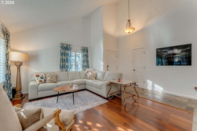 living room with hardwood / wood-style floors and high vaulted ceiling