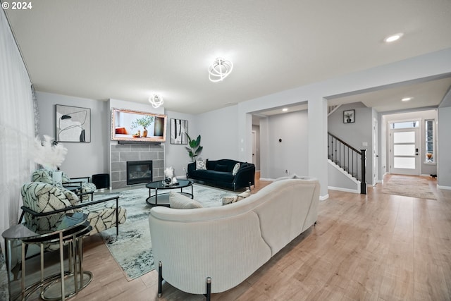 living room featuring light hardwood / wood-style flooring and a tile fireplace