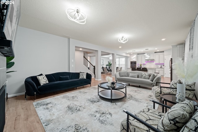 living room with light wood-type flooring and a textured ceiling