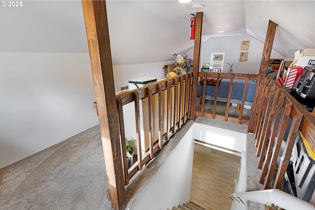 stairway with carpet flooring and lofted ceiling