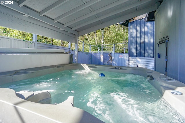 view of swimming pool featuring a hot tub