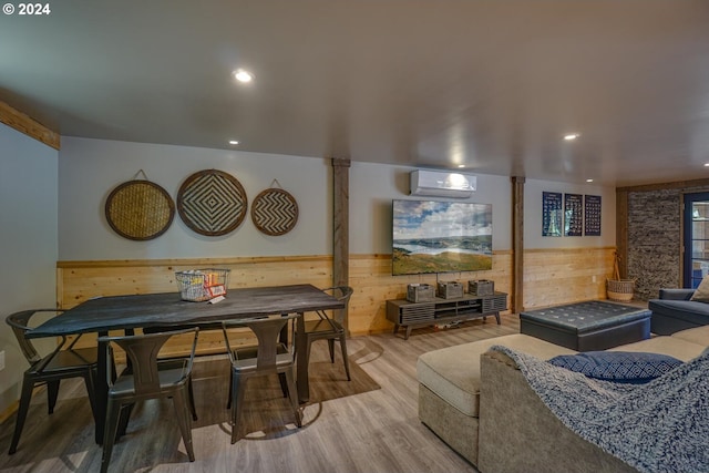 living room with hardwood / wood-style floors, a wall mounted AC, and wood walls