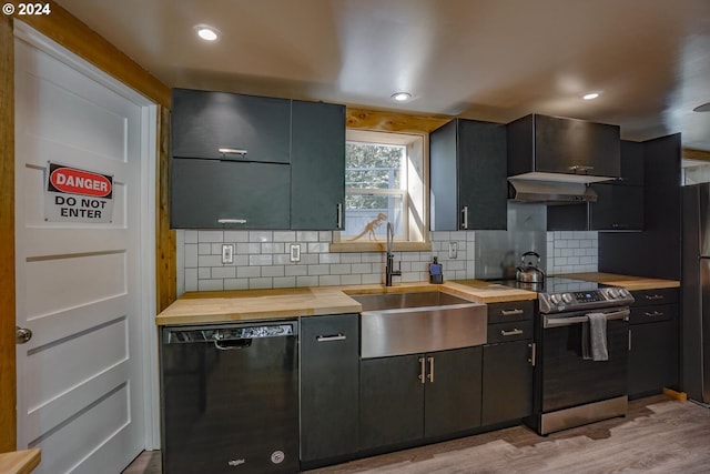 kitchen with backsplash, wooden counters, black appliances, sink, and light hardwood / wood-style floors