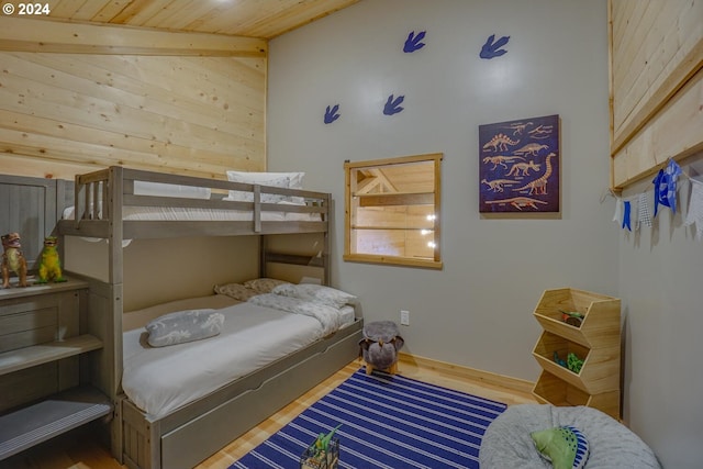 bedroom featuring hardwood / wood-style floors, wooden ceiling, and high vaulted ceiling