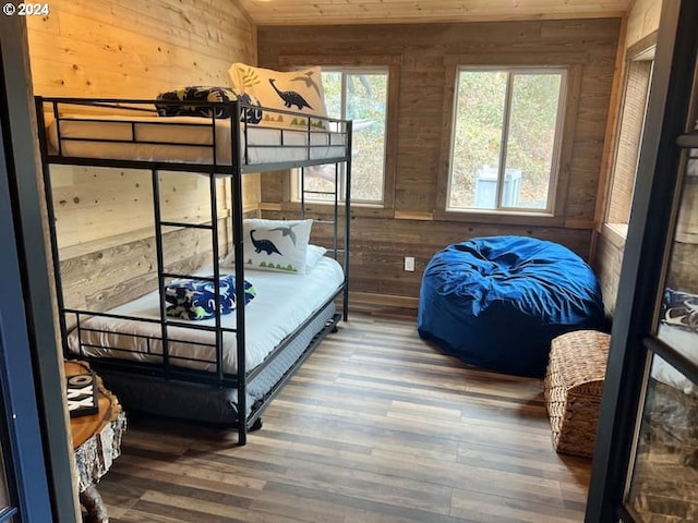 bedroom with wood walls and hardwood / wood-style floors