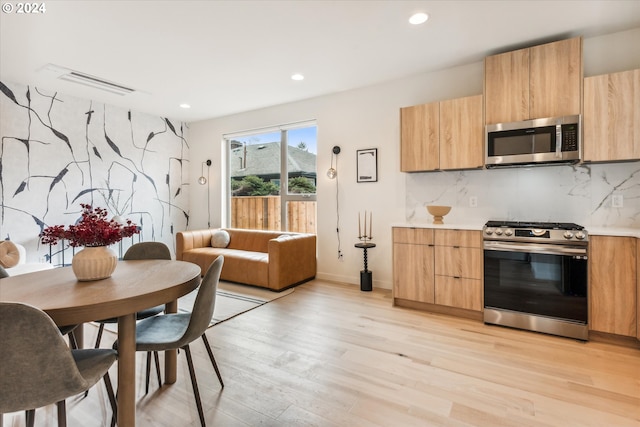 kitchen with tasteful backsplash, light brown cabinetry, stainless steel appliances, and light wood-type flooring