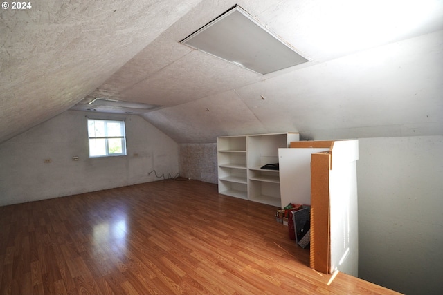 bonus room featuring lofted ceiling and wood-type flooring