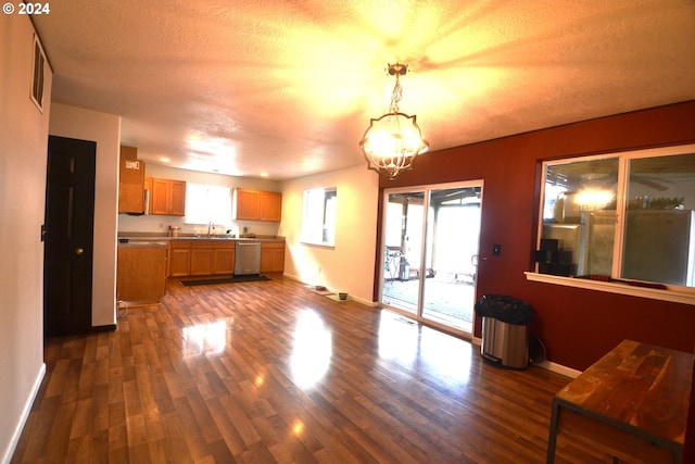 kitchen with pendant lighting, sink, stainless steel dishwasher, and dark hardwood / wood-style floors