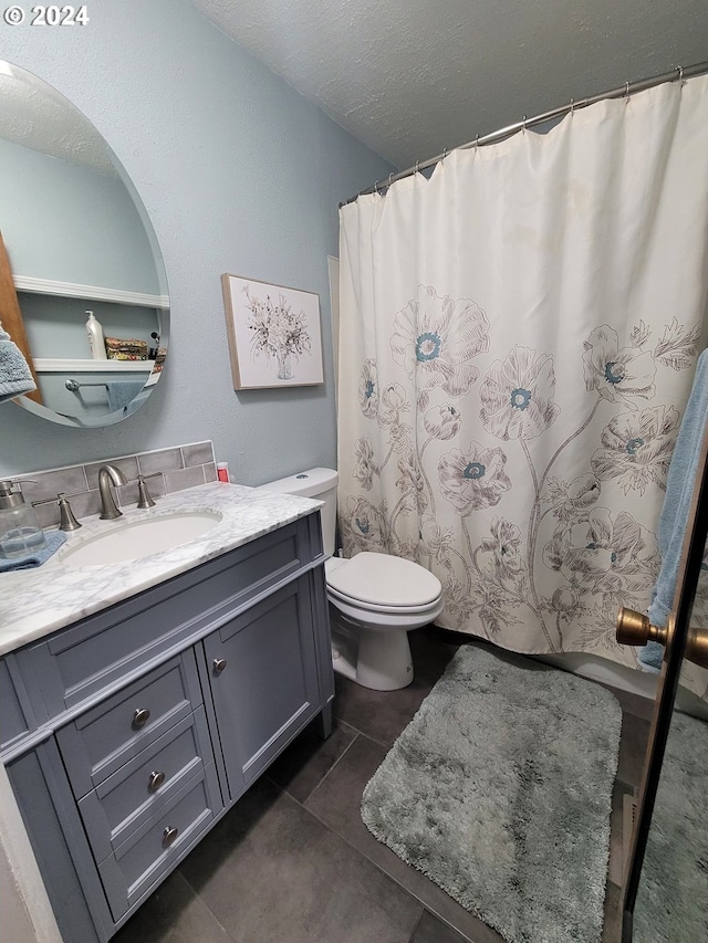 bathroom with tile patterned floors, vanity, toilet, and a textured ceiling