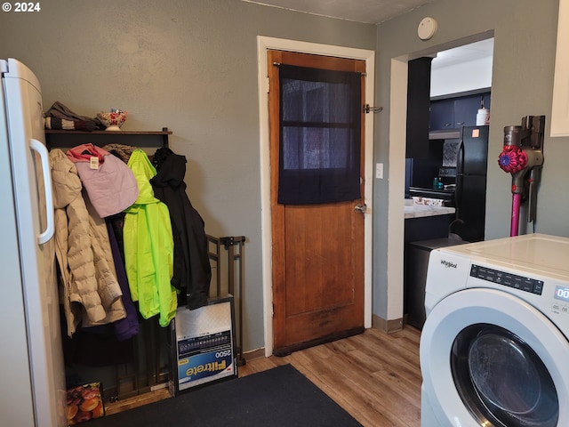 clothes washing area with light hardwood / wood-style floors and washer / clothes dryer