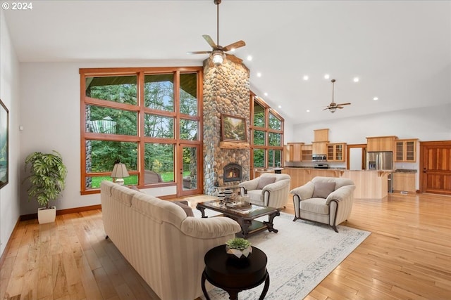 living room featuring ceiling fan, high vaulted ceiling, and light hardwood / wood-style flooring