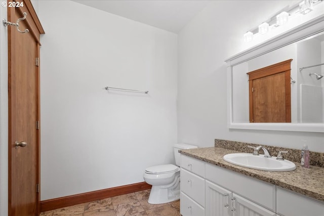 bathroom featuring walk in shower, vanity, and toilet