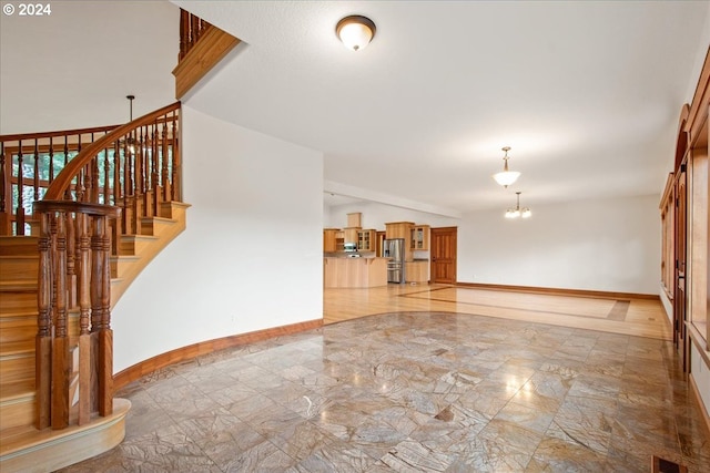 unfurnished living room with an inviting chandelier