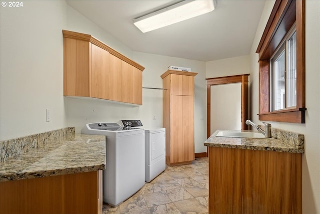 laundry area featuring washer and dryer, sink, and cabinets