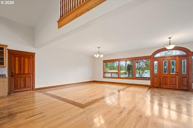 entrance foyer with a chandelier, high vaulted ceiling, and light wood-type flooring