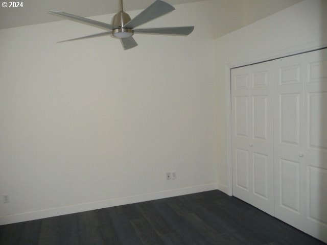 unfurnished bedroom with ceiling fan, dark hardwood / wood-style flooring, and a closet