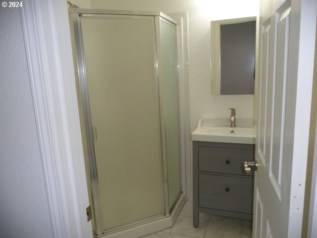 bathroom with vanity and a shower with door