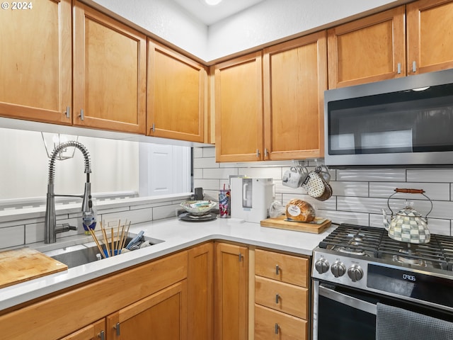 kitchen with decorative backsplash, appliances with stainless steel finishes, and sink