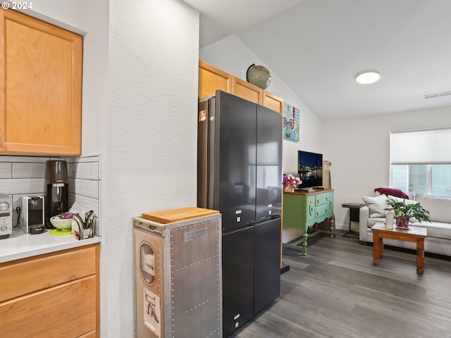 kitchen with vaulted ceiling, dark hardwood / wood-style flooring, light brown cabinets, and fridge