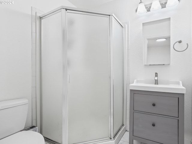 bathroom featuring vanity, toilet, and a shower with door