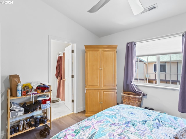 bedroom featuring ensuite bathroom, ceiling fan, vaulted ceiling, and light wood-type flooring