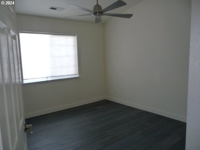 empty room featuring ceiling fan and dark wood-type flooring