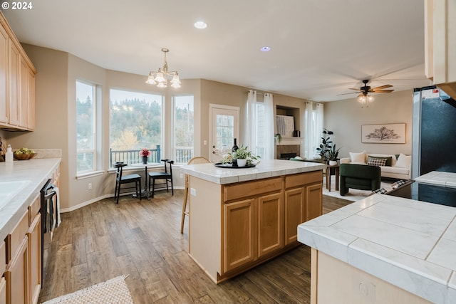 kitchen with tile countertops, a center island, dark hardwood / wood-style flooring, and hanging light fixtures