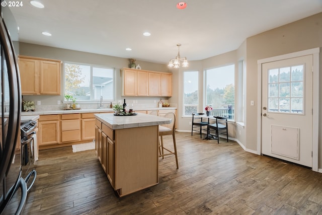 kitchen featuring dark hardwood / wood-style flooring, a center island, and a healthy amount of sunlight