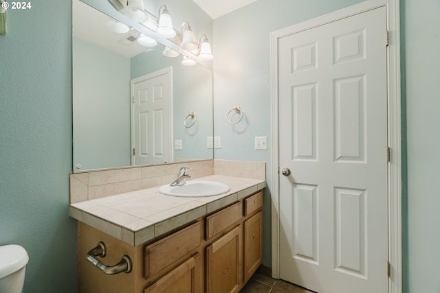 bathroom featuring tile patterned flooring, vanity, and toilet