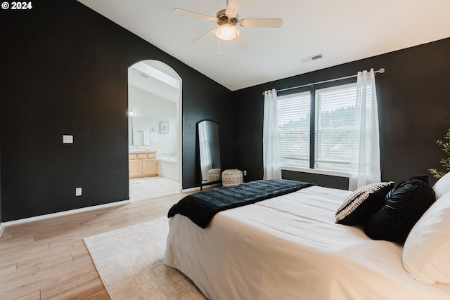 bedroom with ceiling fan, ensuite bathroom, light hardwood / wood-style floors, and lofted ceiling