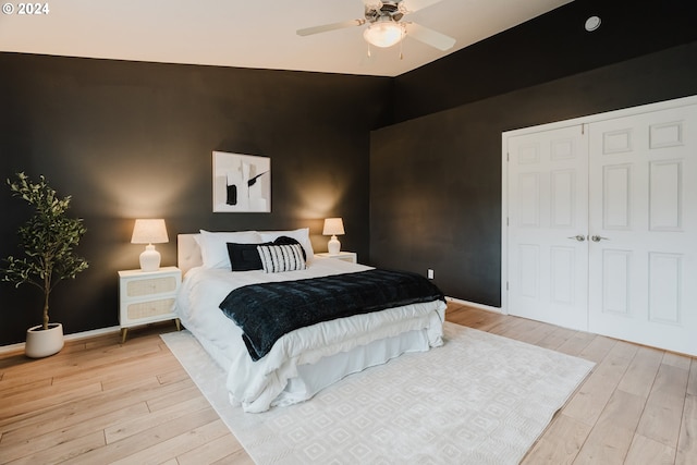 bedroom featuring a closet, ceiling fan, light hardwood / wood-style flooring, and lofted ceiling