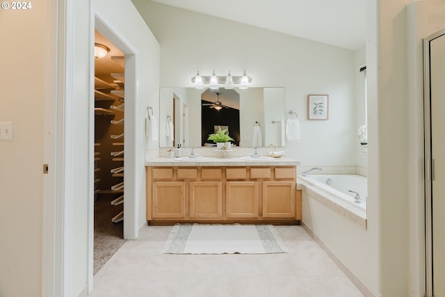 bathroom with tile patterned floors, vanity, a relaxing tiled tub, and lofted ceiling