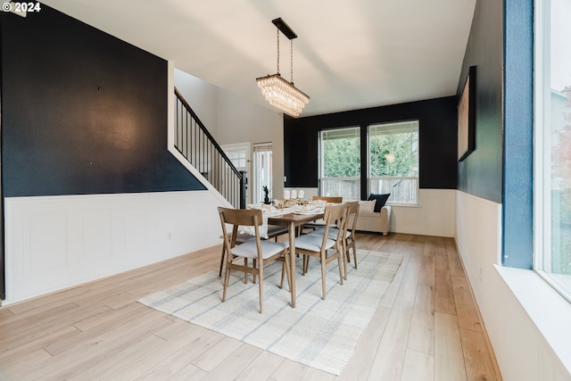 dining space featuring light hardwood / wood-style flooring and a notable chandelier