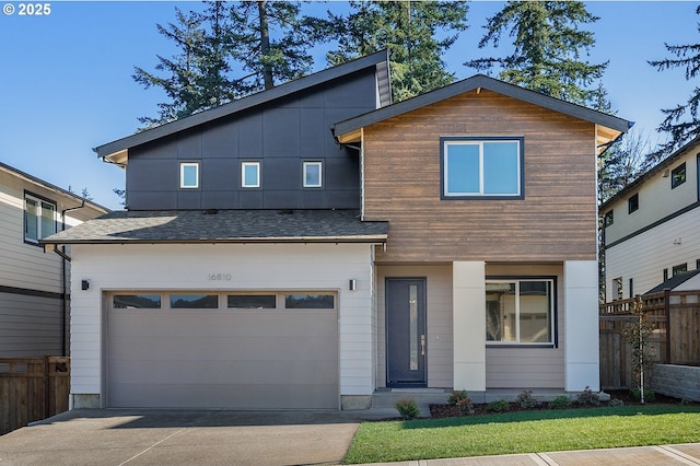 contemporary house with concrete driveway, roof with shingles, a garage, and fence