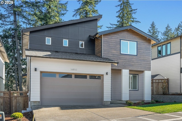 contemporary house featuring concrete driveway, an attached garage, and fence