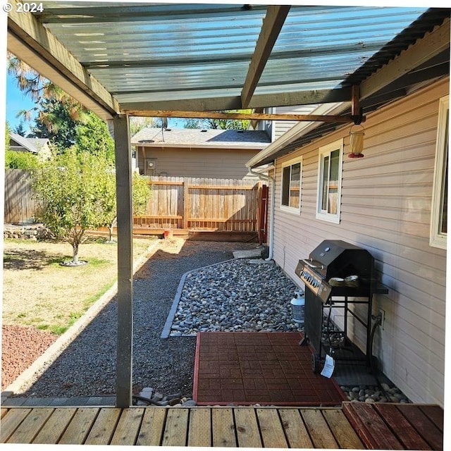 view of patio featuring grilling area, a pergola, and fence