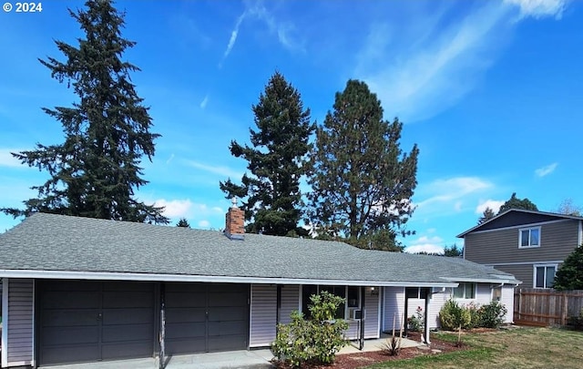 ranch-style house featuring fence, a garage, roof with shingles, and a chimney