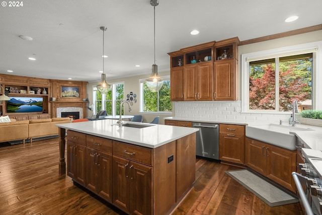 kitchen with stainless steel appliances, sink, dark hardwood / wood-style floors, and a kitchen island with sink