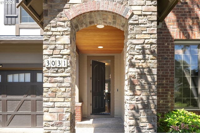 view of exterior entry featuring stone siding and brick siding