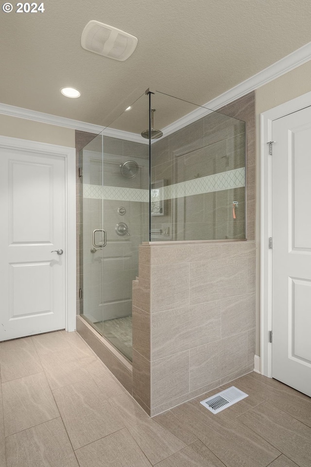 bathroom with tile patterned flooring, a shower with shower door, and ornamental molding