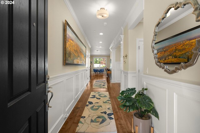 corridor with dark wood-type flooring and crown molding