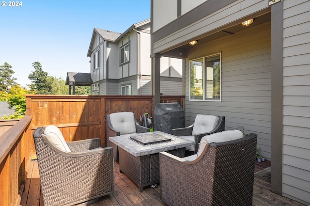 wooden terrace with a fire pit and area for grilling