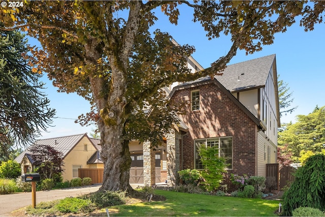 english style home with a garage and a front lawn