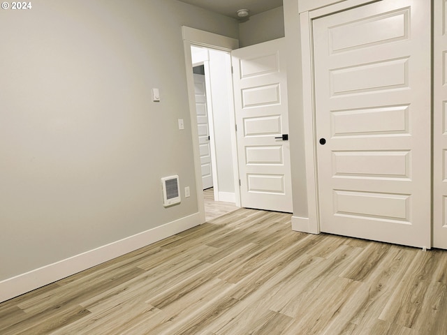 unfurnished bedroom featuring a closet and light hardwood / wood-style flooring