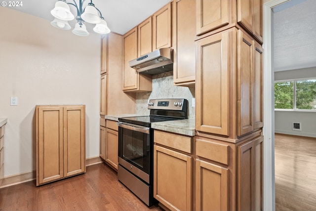 kitchen with decorative backsplash, electric stove, pendant lighting, a chandelier, and dark hardwood / wood-style floors