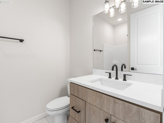 bathroom featuring an inviting chandelier, vanity, toilet, and tile patterned floors