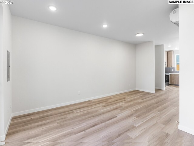 unfurnished living room featuring light wood-type flooring and electric panel