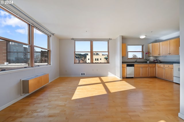 kitchen with white appliances, radiator, and light wood-type flooring