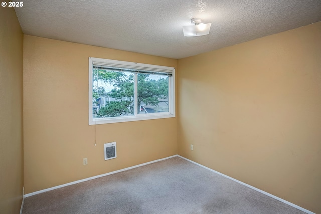 empty room featuring carpet, a textured ceiling, and heating unit